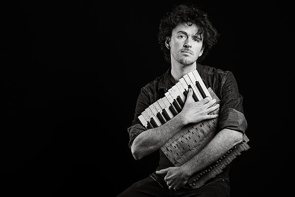 a picture of pianist Ben Cosgrove holding a small accordian