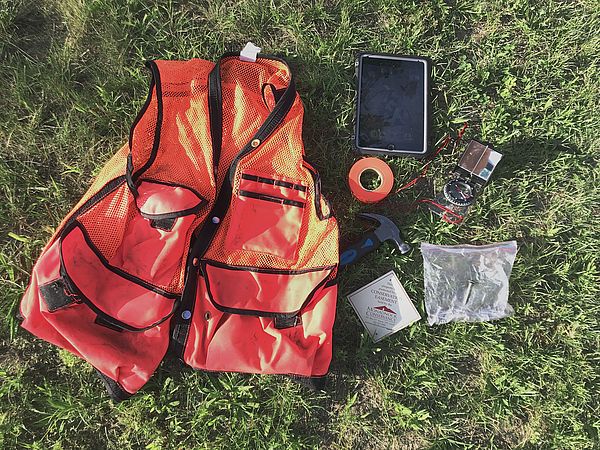 Orange field vest and various items