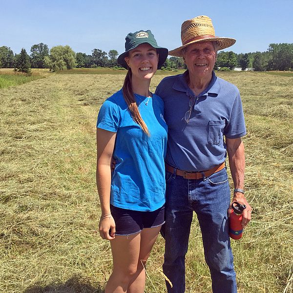 Ingrid Evans and Lucky Evans standing in a hay field
