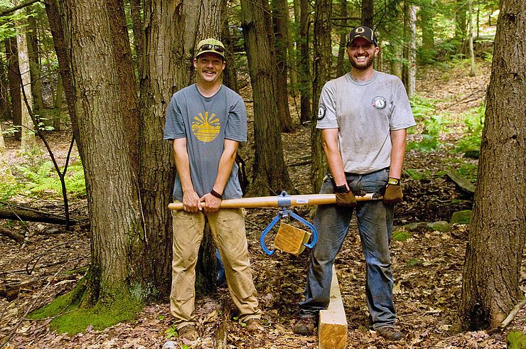 Doug Brown and Rick Brackett using a timber carrier to haul log