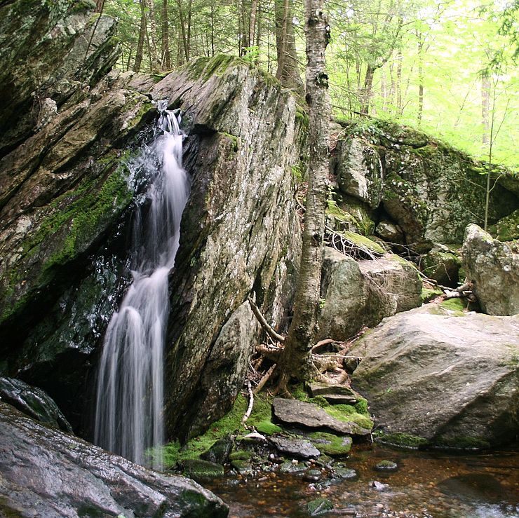 Small waterfall cascading from large glacial boulders