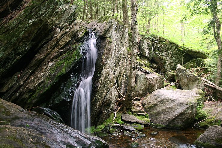 Small waterfall cascading from large glacial boulders