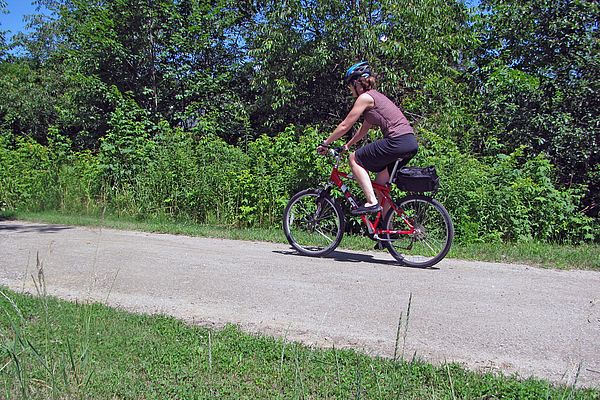 Woman biking along rail trail