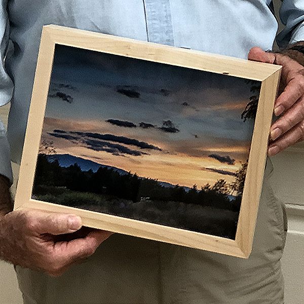 Man's hands cradling framed photo of Mount Monadnock